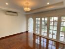 Spacious living room with wooden flooring and large windows