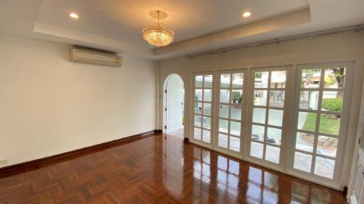 Spacious living room with wooden flooring and large windows