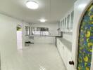 Spacious kitchen with white cabinets and stained glass door