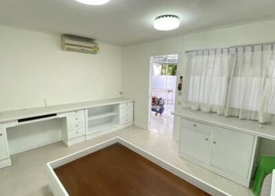 Bright room with white furniture, an air conditioning unit, and a window with curtains