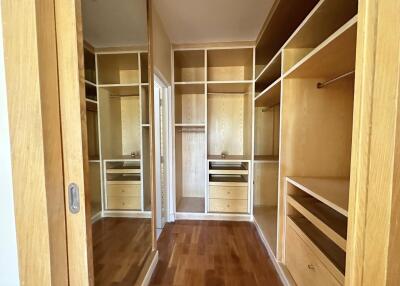 Spacious and well-organized walk-in closet with wooden shelves and drawers