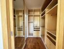 Spacious and well-organized walk-in closet with wooden shelves and drawers