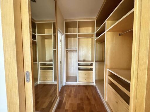 Spacious and well-organized walk-in closet with wooden shelves and drawers