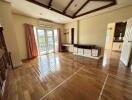 Spacious bedroom with wooden flooring and large windows