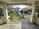 Covered patio area with view of residential street and garden