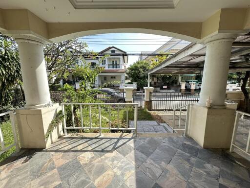 Covered patio area with view of residential street and garden