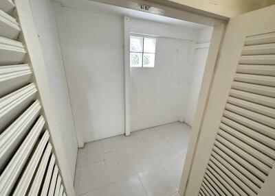 Small white storage room with window