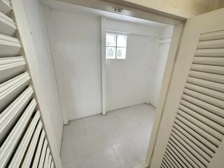 Small white storage room with window