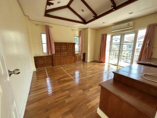 Spacious living room with wooden flooring and large windows