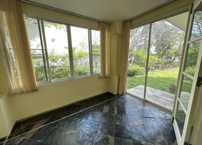 Sunroom with tiled floor and garden view