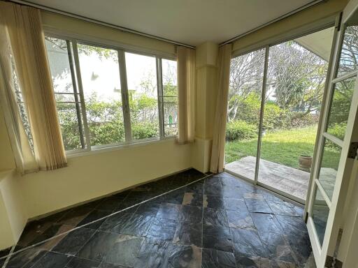 Sunroom with tiled floor and garden view