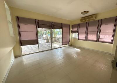 Bright living room with large windows and air conditioning unit.