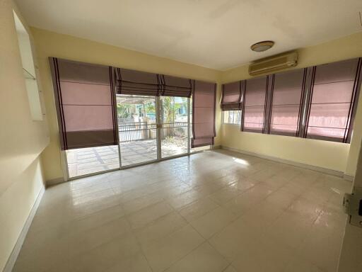 Bright living room with large windows and air conditioning unit.