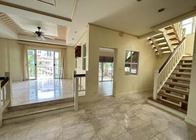 Spacious open-plan living area with large windows and staircase