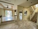 Spacious open-plan living area with large windows and staircase