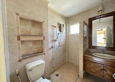 Well-lit bathroom with shower, sink, and toilet