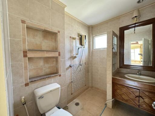 Well-lit bathroom with shower, sink, and toilet