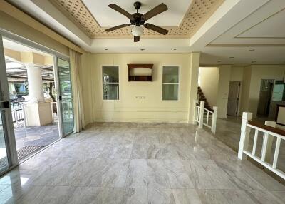 Spacious living room with ceiling fan, sliding glass door, and staircase