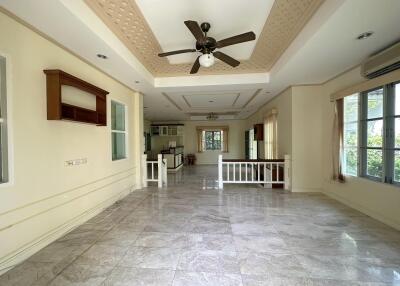 Spacious living room with marble floors, ceiling fan, and large windows