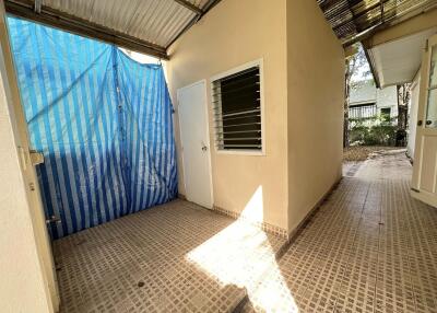 Outdoor utility area with a covered roof and tiled floor