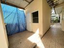 Outdoor utility area with a covered roof and tiled floor