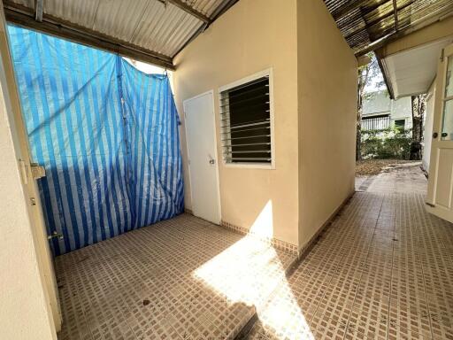 Outdoor utility area with a covered roof and tiled floor