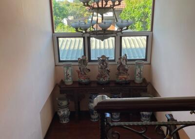 A staircase landing area with decorative items and a chandelier