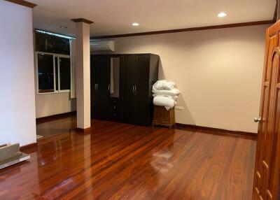 Spacious bedroom with wooden floor and wardrobe