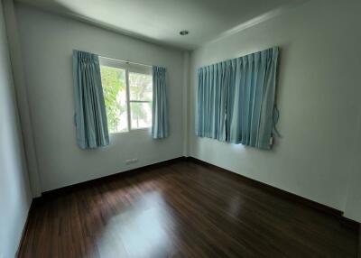 Empty bedroom with two windows and blue curtains