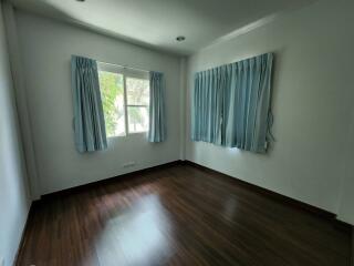 Empty bedroom with two windows and blue curtains