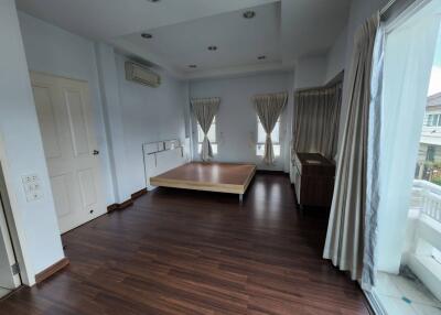 Spacious bedroom with wooden floor and large windows