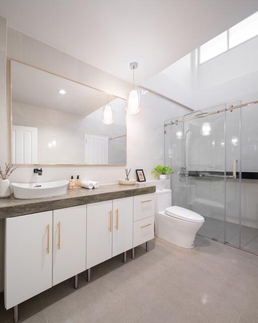 Modern bathroom with large mirror, vanity, and glass shower