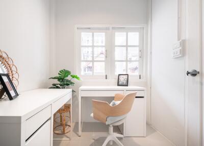 Modern home office with white furniture and natural light