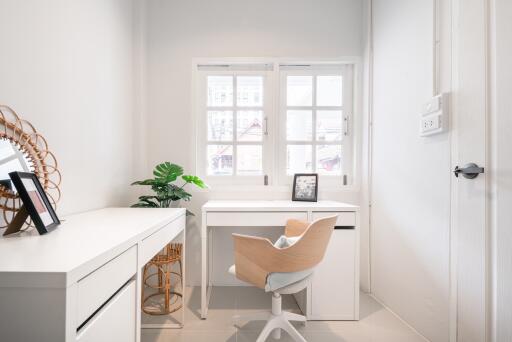 Modern home office with white furniture and natural light