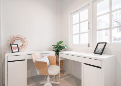 Modern home office with white furniture and natural lighting