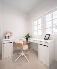 Modern home office with white furniture and natural lighting