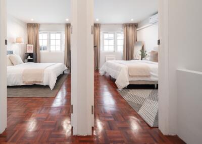 Double bedroom setup with modern decor and hardwood floors