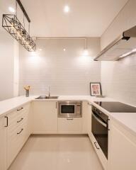 Modern kitchen with white cabinetry and built-in appliances