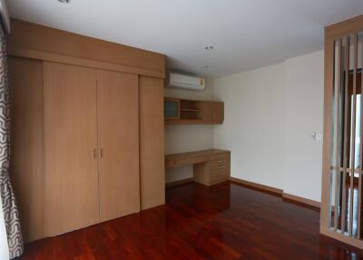 Spacious bedroom with built-in wooden wardrobe and desk