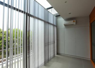 Well-lit balcony with vertical blinds and air conditioning