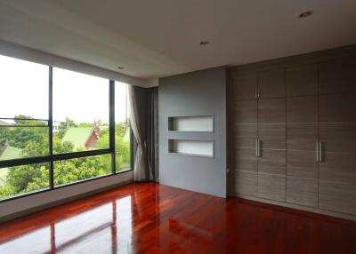 Spacious bedroom with large windows and built-in wardrobe