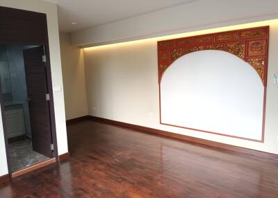 Living room with decorative wooden panel and hardwood floors