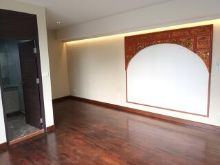 Living room with decorative wooden panel and hardwood floors