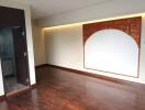 Living room with decorative wooden panel and hardwood floors