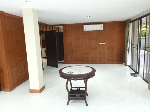 Spacious living room with wooden panel walls and marble floor