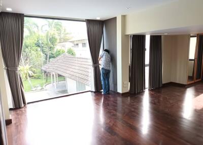 Spacious living room with large windows and wooden flooring