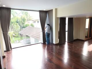 Spacious living room with large windows and wooden flooring