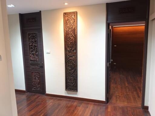 hallway with wooden doors and decorative panels