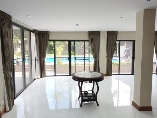 Spacious living room with large windows and pool view