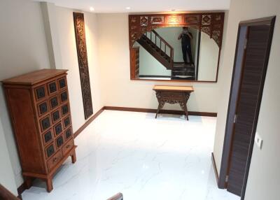 A well-lit and decorated living room with wooden furniture and white tiled floor